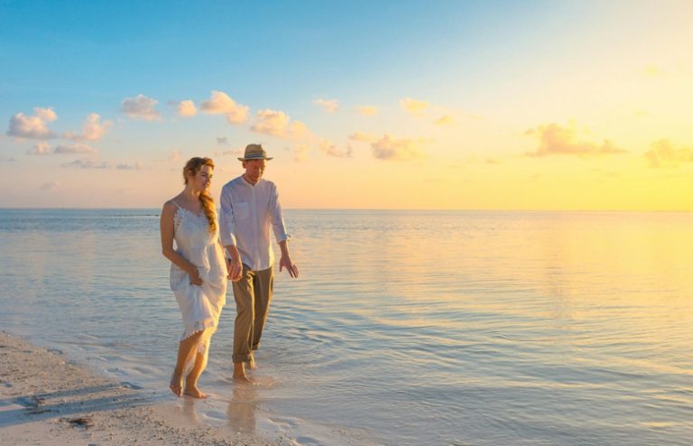 Happy couple walking on beach vacation